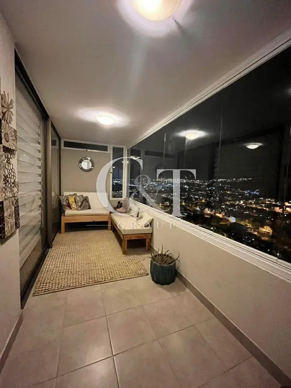 Terraza cerrada con vista nocturna a la ciudad