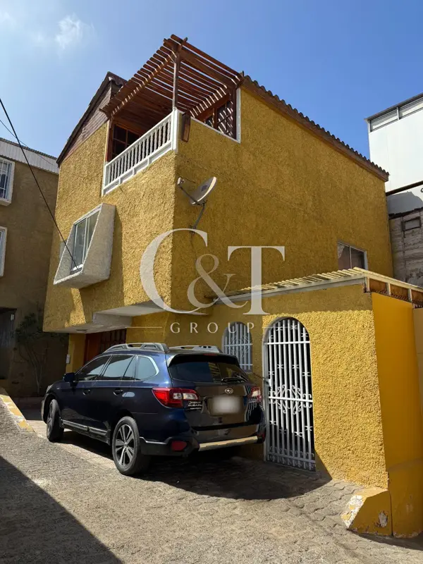 Fachada con estacionamiento y terraza con pérgola